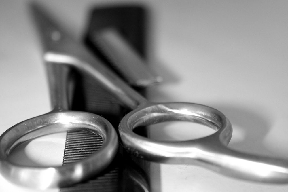 A pair of barber scissors and a comb
