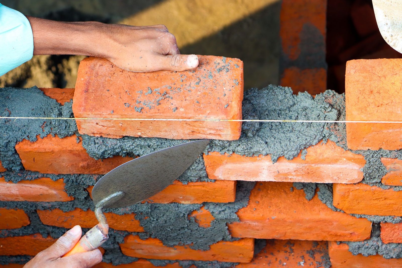 A bricklayer laying brick with a trowel