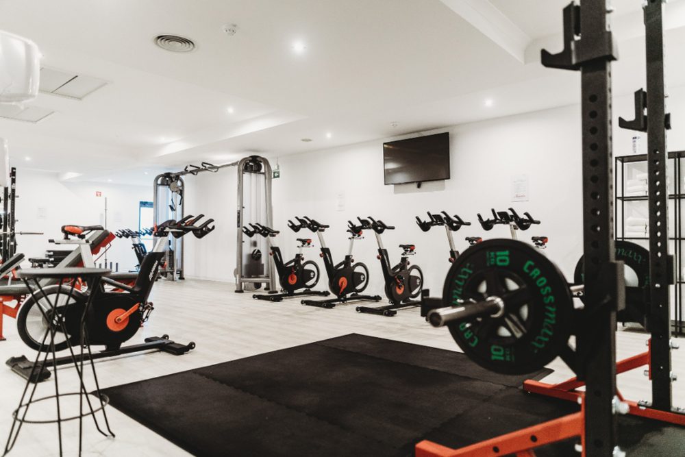 A clean modern gym interior with weights and exercise bikes