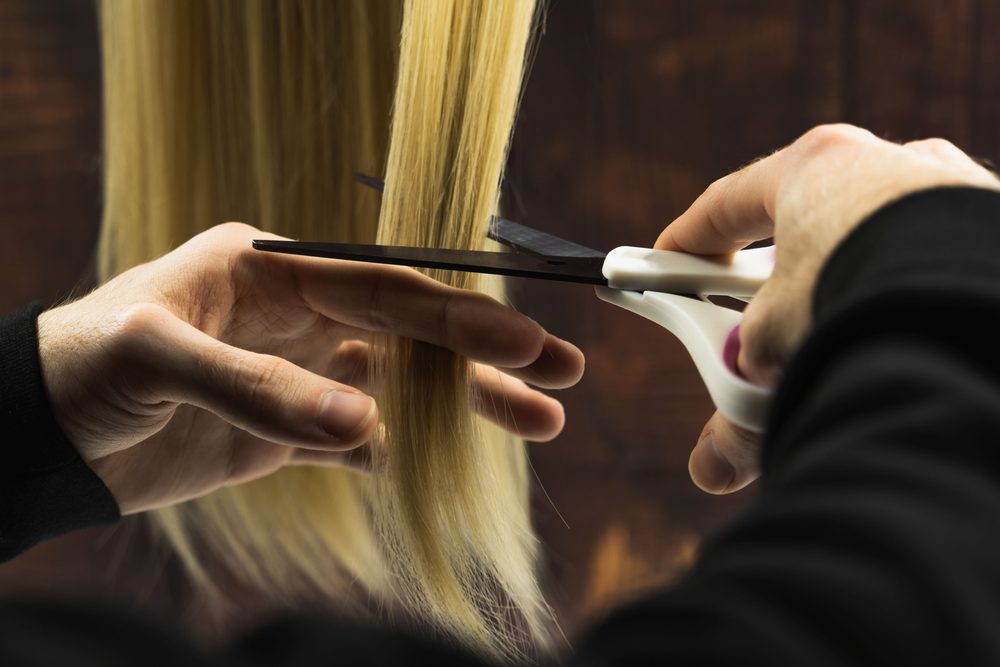 A hairdresser cutting a client's hair with scissors